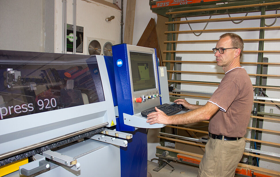 Mitarbeiter an der computergesteuerten Kantenanleimmaschine